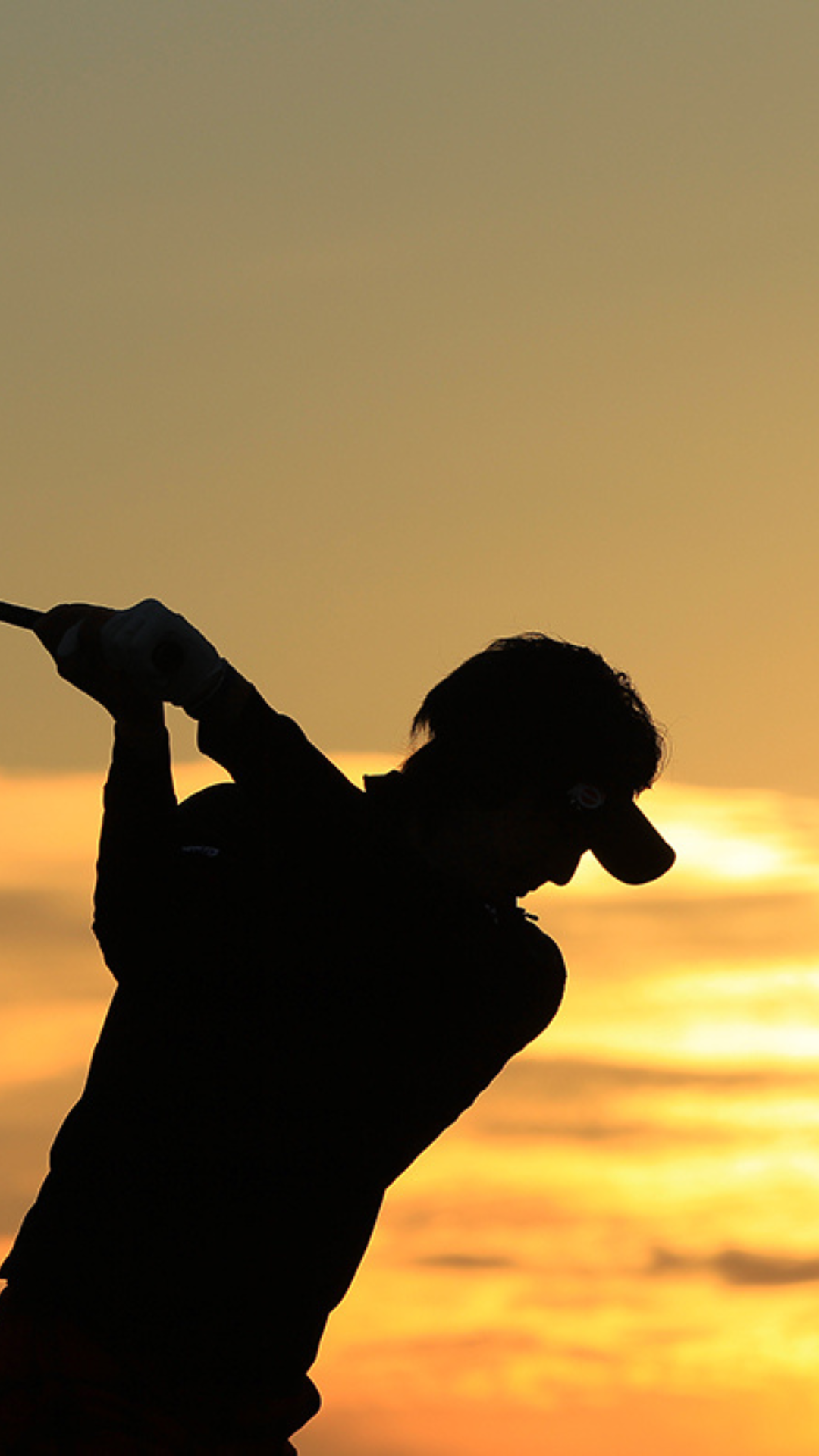 夕日をバックにしたゴルファーのシルエット